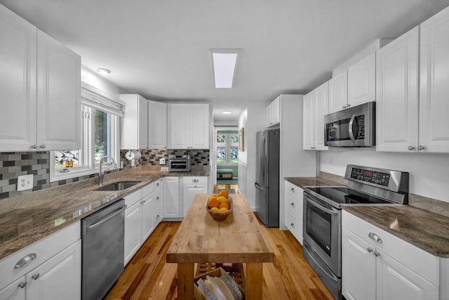 449 Mohegan Avenue Parkway, Waterford, CT 06375 - kitchen with stainless steel appliances, light wood-style flooring, healthy amount of natural light, and white cabinetry