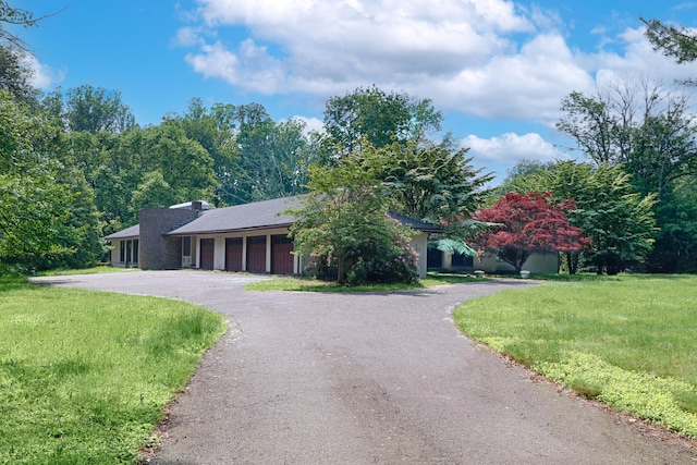 3853 Congress St, Fairfield, CT 06824 - view of front of home with a garage, asphalt driveway, and a front yard