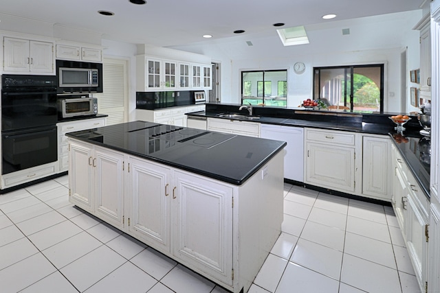 3853 Congress St, Fairfield, CT 06824 - kitchen with black appliances, a center island, dark countertops, white cabinetry, and recessed lighting