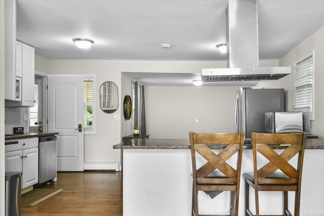 198 Macon Dr, Bridgeport, CT 06606 - kitchen featuring extractor fan, stainless steel appliances, dark wood-type flooring, white cabinets, and tasteful backsplash