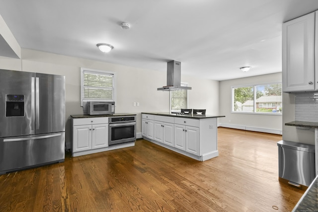 198 Macon Dr, Bridgeport, CT 06606 - kitchen featuring stainless steel appliances, ventilation hood, a peninsula, dark countertops, and dark wood-type flooring