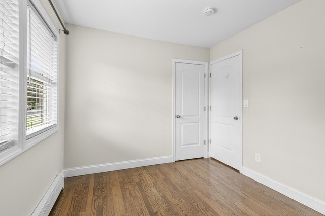 198 Macon Dr, Bridgeport, CT 06606 - unfurnished bedroom featuring wood finished floors and a baseboard heating unit