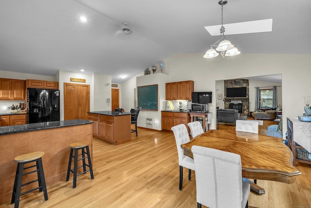 41 Fog Plain Rd, Waterford, CT 06385 - dining space with lofted ceiling, light wood-style floors, a skylight, and a fireplace