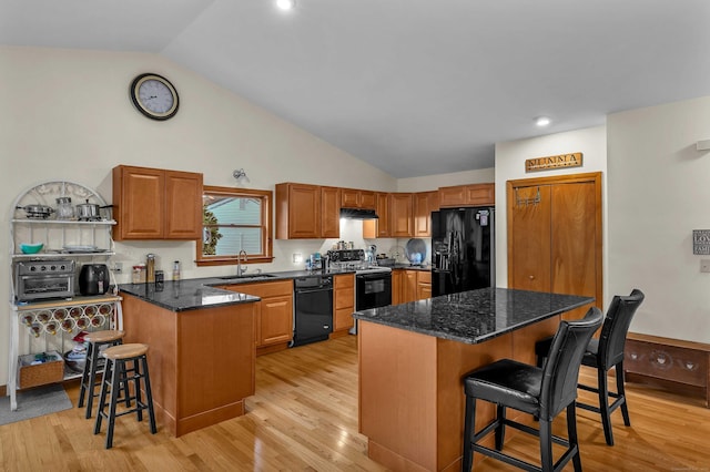 41 Fog Plain Rd, Waterford, CT 06385 - kitchen with black appliances, a breakfast bar, light wood-type flooring, dark stone counters, and recessed lighting