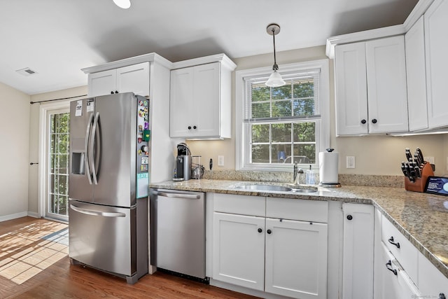 76 Valley View Rd, Norwalk, CT 06851 - kitchen with appliances with stainless steel finishes, wood finished floors, white cabinetry, and healthy amount of natural light