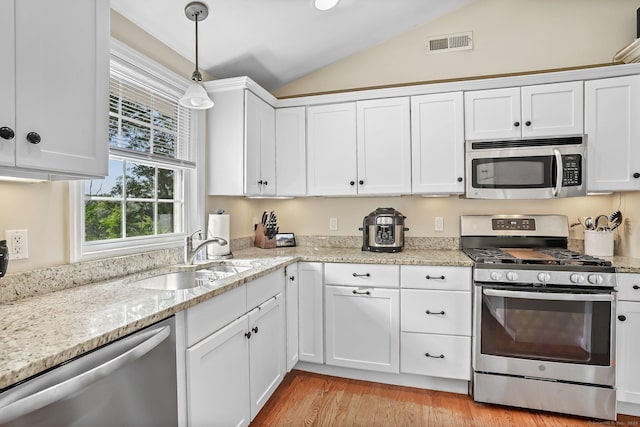 76 Valley View Rd, Norwalk, CT 06851 - kitchen with appliances with stainless steel finishes, lofted ceiling, white cabinets, pendant lighting, and light wood-style floors