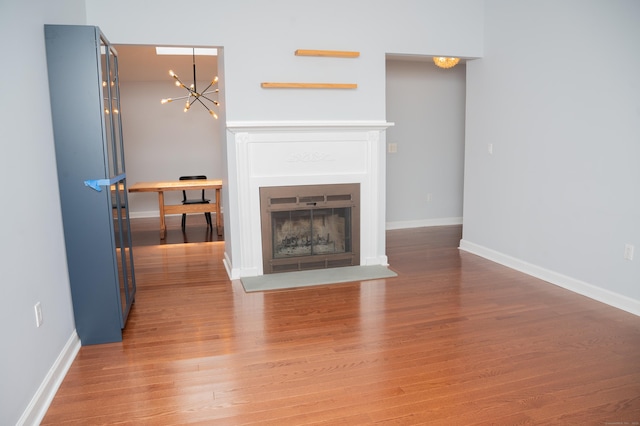 234 Greens Farm Rd Unit 234, Branford, CT 06405 - unfurnished living room with a chandelier, light wood-type flooring, and a glass covered fireplace