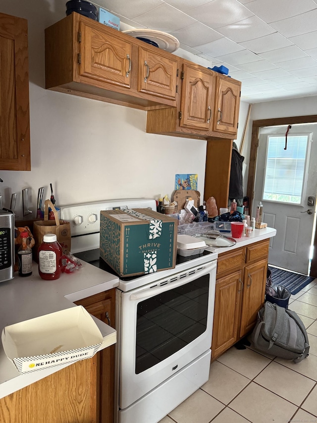74 Pine Rd, East Haddam, CT 06423 - kitchen featuring white range with electric stovetop, light tile patterned floors, light countertops, and brown cabinets