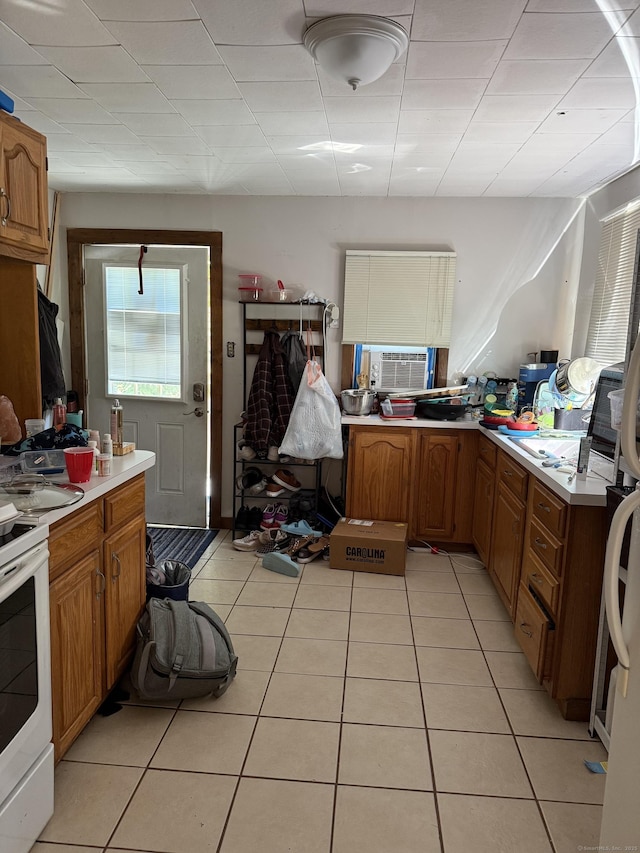 74 Pine Rd, East Haddam, CT 06423 - kitchen with light tile patterned flooring, light countertops, brown cabinets, white electric range oven, and cooling unit