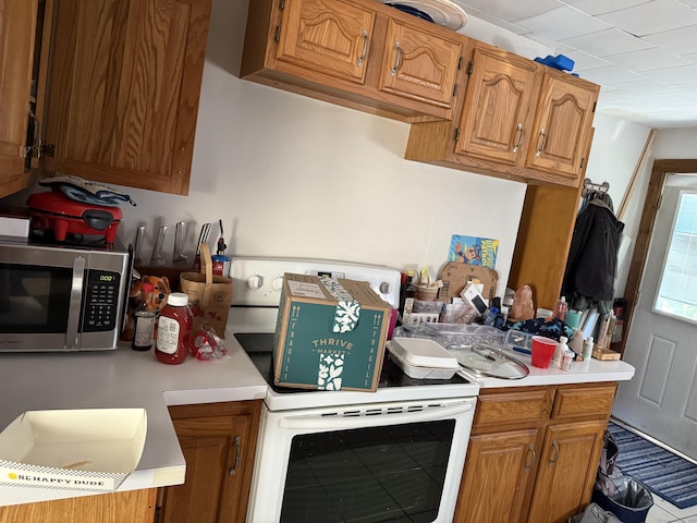 74 Pine Rd, East Haddam, CT 06423 - kitchen with stainless steel microwave, white range with electric cooktop, light countertops, and brown cabinets