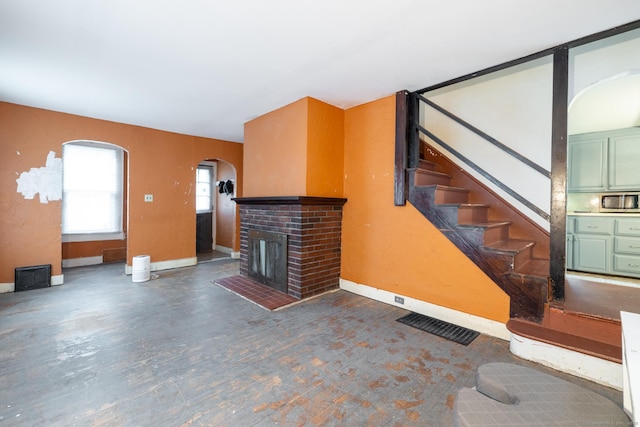 370 Waterville St, Waterbury, CT 06710 - unfurnished living room with arched walkways, a brick fireplace, and stairway