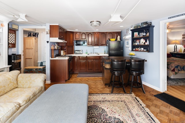 696 Kent Rd, New Milford, CT 06755 - kitchen with black appliances, recessed lighting, light countertops, a breakfast bar area, and open floor plan