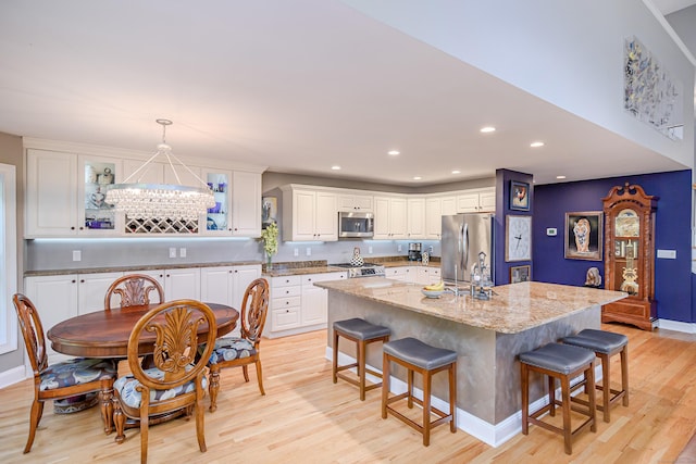 10 Harmony Trl Unit 10, New Milford, CT 06776 - kitchen featuring stainless steel appliances, a breakfast bar area, light wood-style floors, white cabinets, and recessed lighting