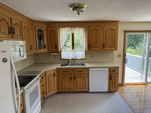 109 Ashley Rd, Bristol, CT 06010 - kitchen with white appliances, light countertops, brown cabinetry, and a textured ceiling