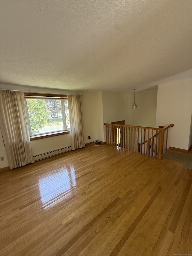 109 Ashley Rd, Bristol, CT 06010 - spare room featuring a baseboard heating unit, light wood-type flooring, and a textured ceiling