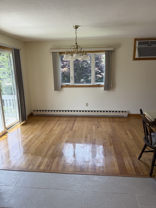 109 Ashley Rd, Bristol, CT 06010 - unfurnished dining area with a wall mounted AC, wood-type flooring, a baseboard radiator, a chandelier, and a textured ceiling