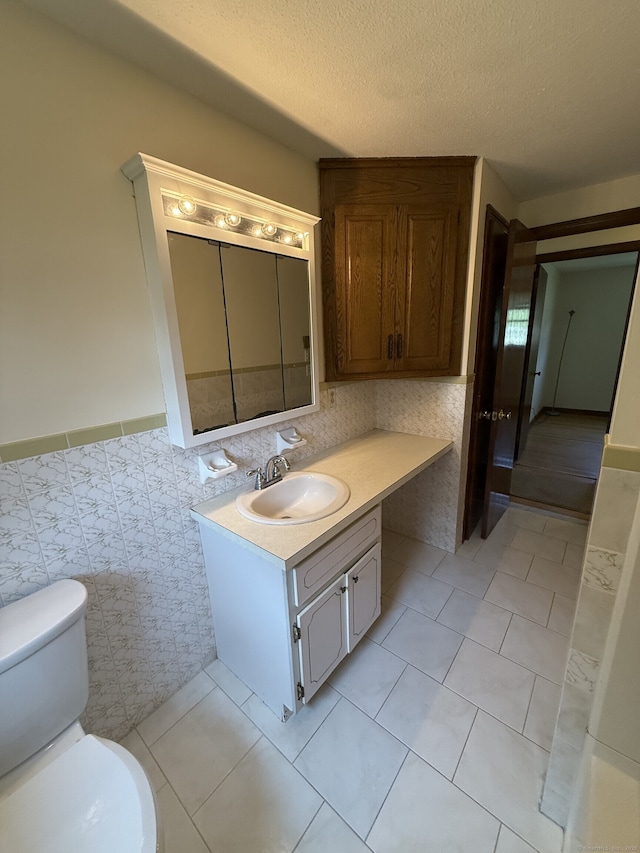 109 Ashley Rd, Bristol, CT 06010 - bathroom with tile walls, vanity, wainscoting, tile patterned flooring, and a textured ceiling