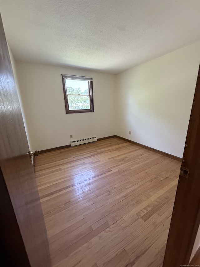 109 Ashley Rd, Bristol, CT 06010 - spare room featuring a baseboard heating unit, light wood-style flooring, and a textured ceiling
