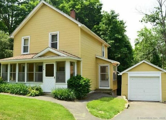 7 Dennis Ln, Stafford, CT 06076 - view of front of house featuring an outbuilding, a chimney, asphalt driveway, a detached garage, and a sunroom
