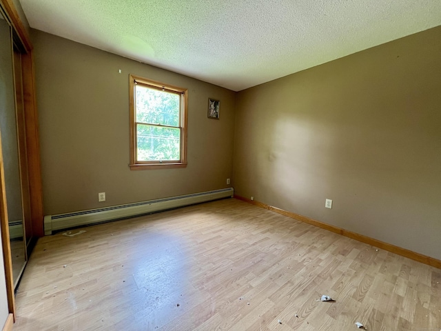67 Harold Rd, Farmington, CT 06032 - unfurnished room with a baseboard heating unit, light wood-style flooring, and a textured ceiling