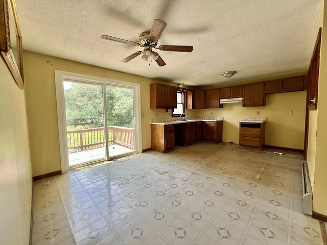 67 Harold Rd, Farmington, CT 06032 - kitchen with under cabinet range hood, a textured ceiling, a ceiling fan, light countertops, and light floors