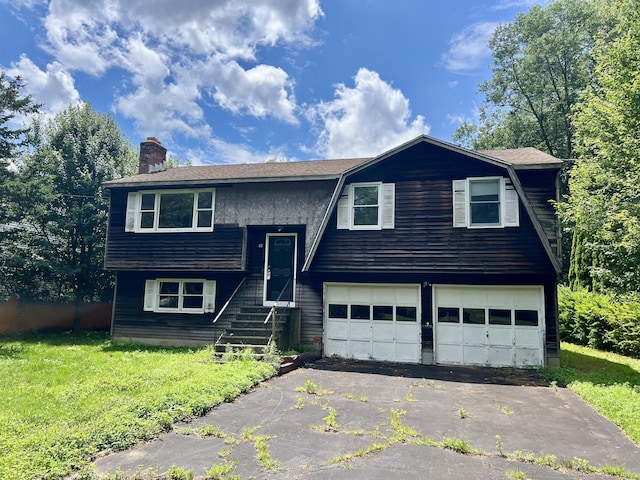 67 Harold Rd, Farmington, CT 06032 - raised ranch with an attached garage, a chimney, driveway, a gambrel roof, and a front lawn