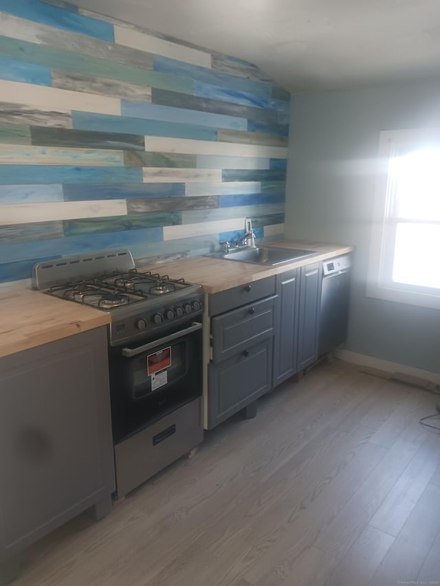 34 Arlington St, West Haven, CT 06516 - kitchen with stainless steel gas range, butcher block countertops, light wood finished floors, dishwasher, and wooden walls