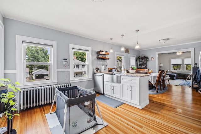 33 Hugh St, West Hartford, CT 06119 - kitchen featuring radiator heating unit, stainless steel dishwasher, white cabinetry, and plenty of natural light