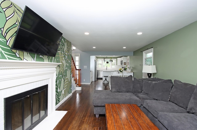 1357 Meriden Ave, Southington, CT 06489 - living area with dark wood-style flooring, recessed lighting, a glass covered fireplace, stairs, and wallpapered walls