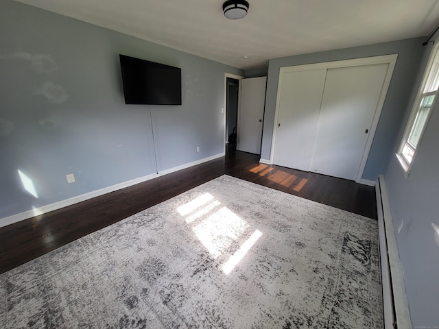 1357 Meriden Ave, Southington, CT 06489 - unfurnished bedroom featuring dark wood-style flooring, a closet, and a baseboard heating unit