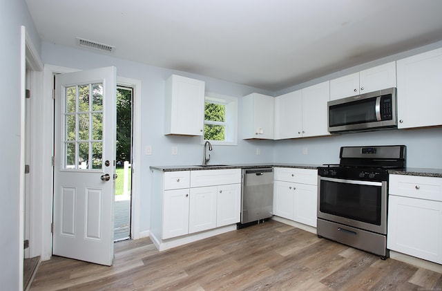 5 Golden Hill Ave, Danbury, CT 06811 - kitchen featuring stainless steel appliances, light wood-type flooring, dark countertops, and white cabinetry