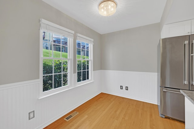 97 Park Ave Unit 70, Danbury, CT 06810 - unfurnished dining area with wainscoting, a chandelier, light wood-style flooring, and plenty of natural light