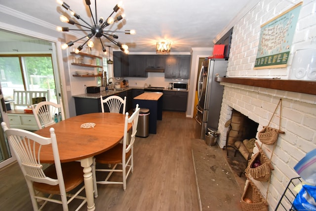 130 Olde Stage Rd, Glastonbury, CT 06033 - dining room featuring crown molding, a chandelier, wood finished floors, and a brick fireplace