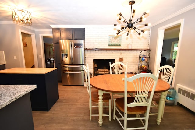 130 Olde Stage Rd, Glastonbury, CT 06033 - dining space featuring a chandelier, radiator, wood finished floors, ornamental molding, and a fireplace