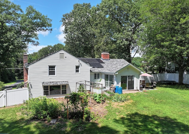 130 Olde Stage Rd, Glastonbury, CT 06033 - rear view of house featuring a chimney, roof mounted solar panels, and a fenced backyard