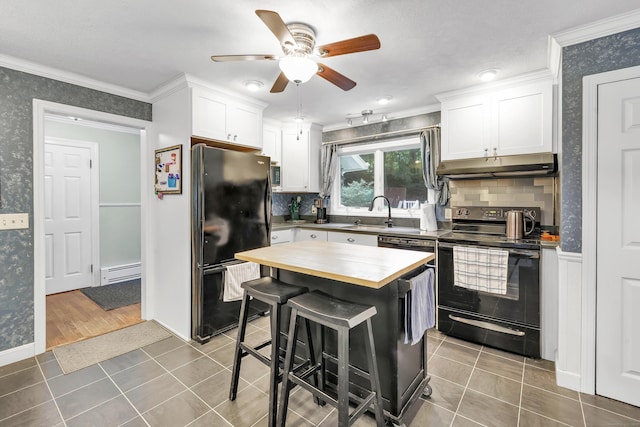 680 Wheelers Farms Rd, Milford, CT 06461 - kitchen featuring black appliances, under cabinet range hood, wooden counters, wallpapered walls, and a baseboard radiator