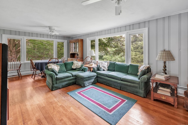 680 Wheelers Farms Rd, Milford, CT 06461 - living area with ceiling fan, baseboard heating, wood finished floors, and a decorative wall