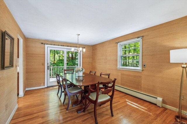 128 Carriage Dr, Avon, CT 06001 - dining area featuring a baseboard radiator, a chandelier, wood finished floors, and wood walls