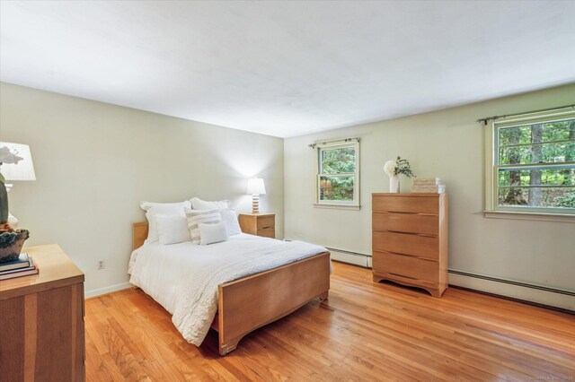 128 Carriage Dr, Avon, CT 06001 - bedroom featuring multiple windows, light wood-style floors, and a baseboard radiator