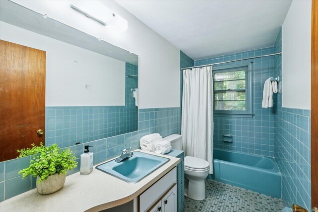 128 Carriage Dr, Avon, CT 06001 - full bath with tile walls, vanity, shower / tub combo with curtain, tile patterned floors, and wainscoting