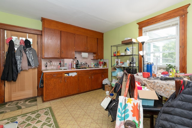 213 Easton Ave, Waterbury, CT 06704 - kitchen with light countertops, brown cabinetry, backsplash, and light flooring
