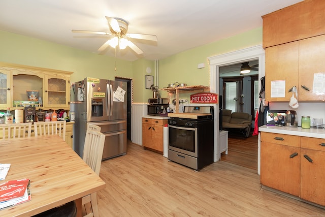 213 Easton Ave, Waterbury, CT 06704 - kitchen with stainless steel appliances, ceiling fan, light countertops, light wood-style floors, and a wainscoted wall