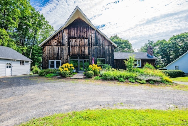 412 Goshen Rd, Litchfield, CT 06759 - view of front facade featuring board and batten siding, a barn, an outbuilding, and a chimney