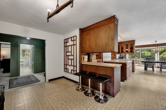 412 Goshen Rd, Litchfield, CT 06759 - kitchen with light countertops, glass insert cabinets, a peninsula, freestanding refrigerator, and light floors