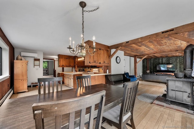 412 Goshen Rd, Litchfield, CT 06759 - dining space with a chandelier, light wood-type flooring, a wall mounted air conditioner, a baseboard radiator, and a wood stove