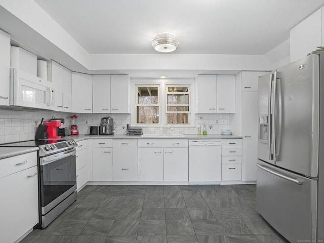 465 Edward St, Fairfield, CT 06824 - kitchen featuring appliances with stainless steel finishes, light countertops, backsplash, and white cabinets