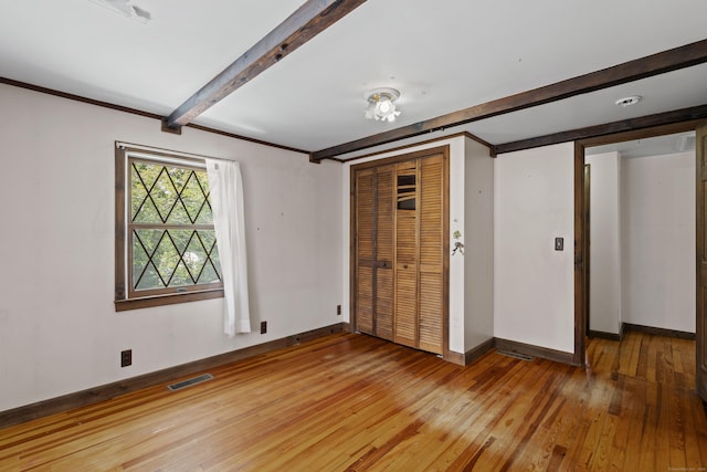 905 Meriden Ave, Southington, CT 06489 - unfurnished bedroom featuring beamed ceiling, light wood-style flooring, and a closet