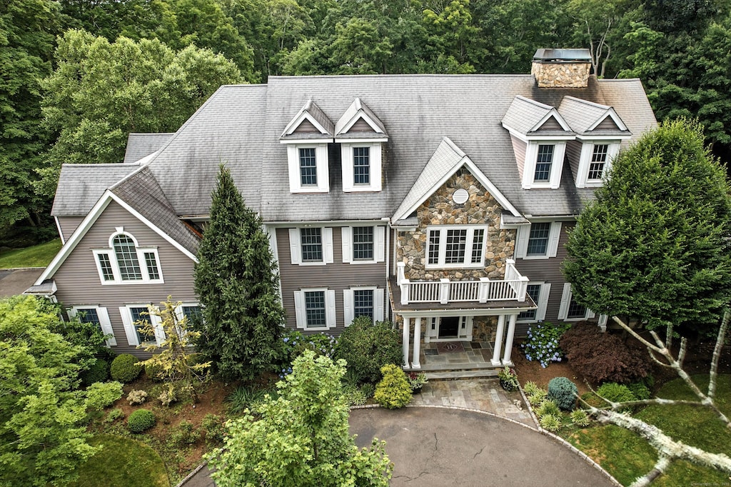 40 Cascade Rd, Stamford, CT 06903 - shingle-style home featuring stone siding, a chimney, a wooded view, and a balcony