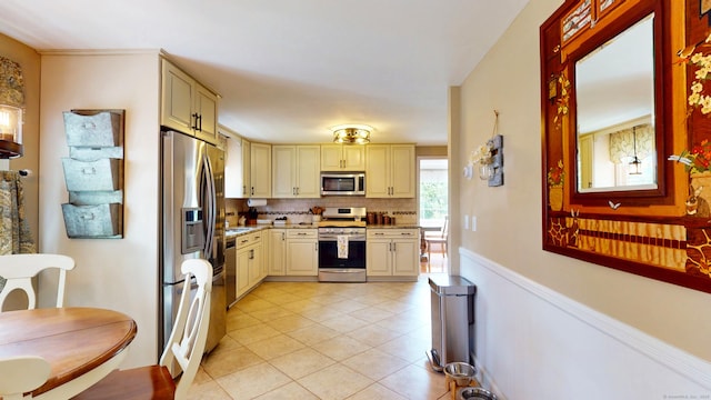 3 Lower Lake Rd, Danbury, CT 06811 - kitchen featuring appliances with stainless steel finishes, cream cabinets, light tile patterned flooring, and tasteful backsplash