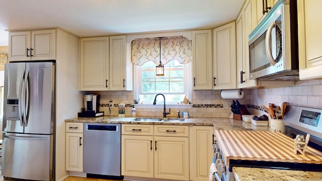 3 Lower Lake Rd, Danbury, CT 06811 - kitchen with stainless steel appliances, cream cabinets, backsplash, and light stone counters